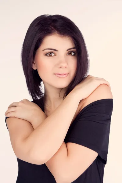 Portrait of a girl hugging her arms in a black dress (retro) — Stock Photo, Image