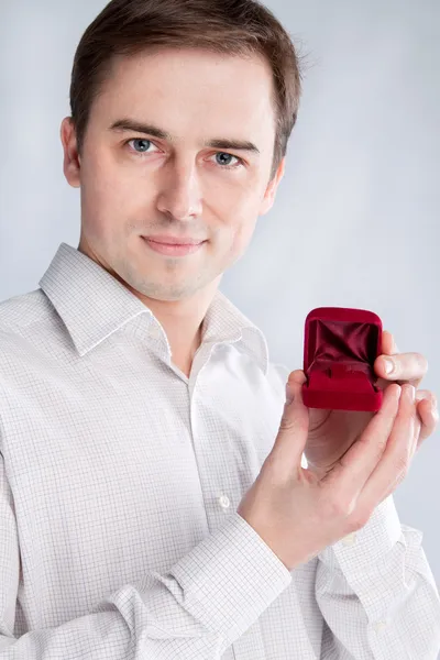 Guy segura caixa de jóias perto do rosto — Fotografia de Stock
