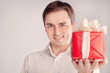 Man holding a box with a gift in front of a close-up (retro) clipart