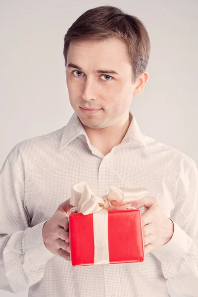 Homem segurando uma caixa com um presente com ambas as mãos (retro ) — Fotografia de Stock