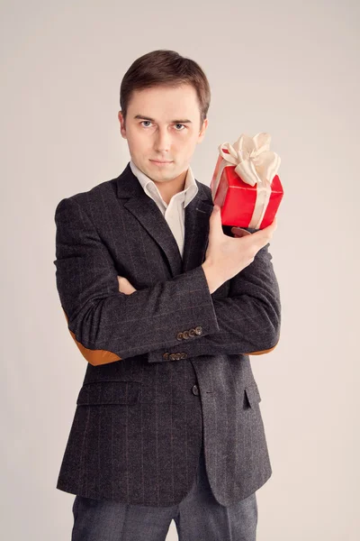 Guy holding a gift near the face, a stern look (retro) — Stock Photo, Image