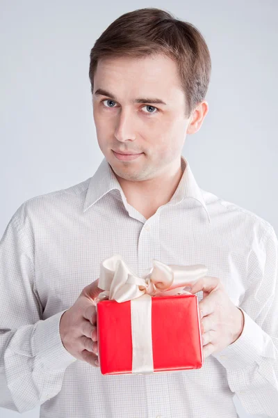 Man holding a box with a gift with both hands Stock Photo