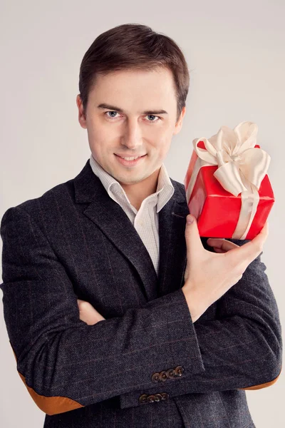 Mann hält ein Geschenk in der Nähe des Gesichts, sexy Look (retro) — Stockfoto