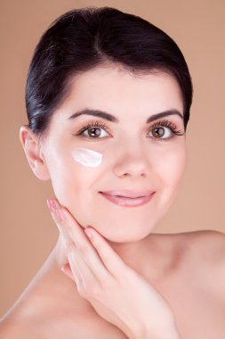 meisje met crème op haar Wang en hand in de buurt van Wang profiel