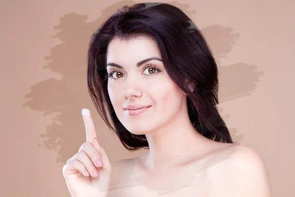 Smiling girl with cream on her finger unusual toning — Stock Photo, Image