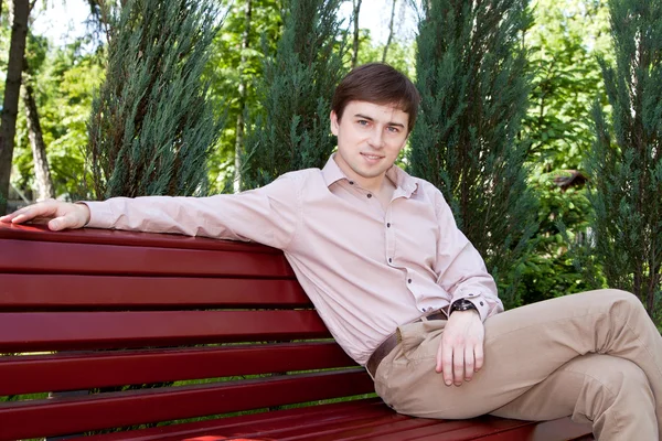Birini bekliyor bir bankta oturan genç bir adam — Stok fotoğraf