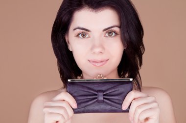 bir çanta onun önünde tutan ve gülümseyen kız