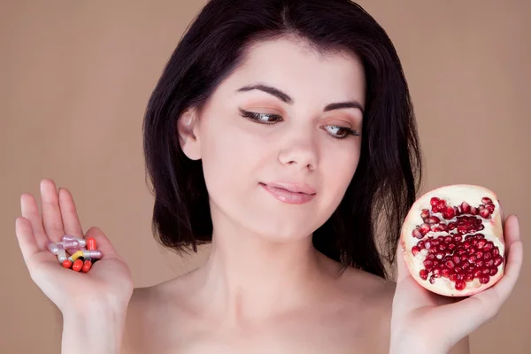 Chica elige entre pastillas y frutas — Foto de Stock