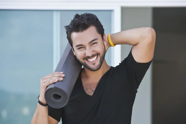 Portret van een man die houdt van yoga mat Stockfoto
