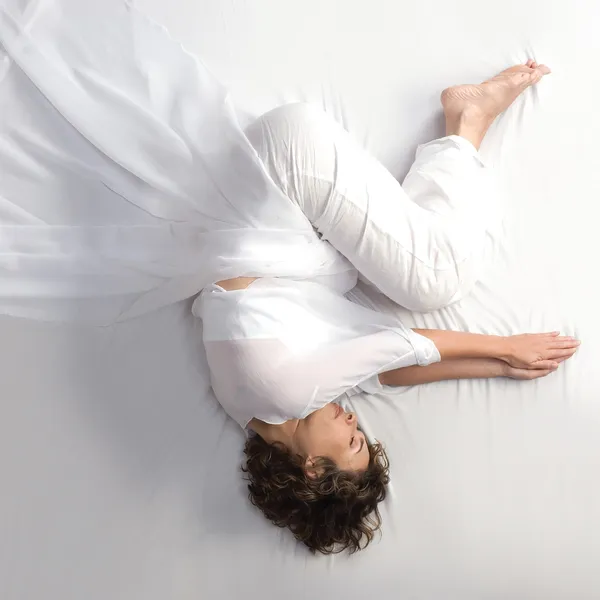 Woman in fetal position on white background — Stock Photo, Image