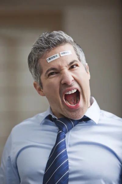 Retrato de un hombre de negocios gritando con código de barras en la frente — Foto de Stock