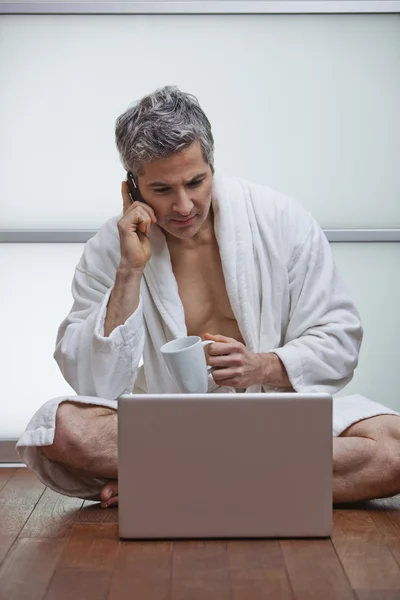 Mannen klädd i morgonrock och talar i en mobiltelefon — Stockfoto