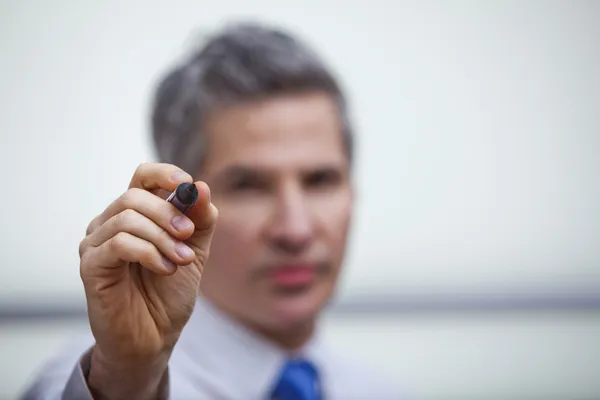 Empresário apontando com uma caneta de ponta de feltro — Fotografia de Stock