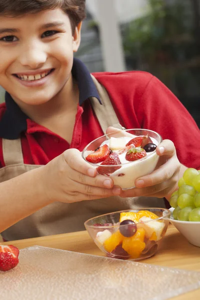 Niño sosteniendo un tazón de ensalada de frutas y sonriendo — Foto de Stock