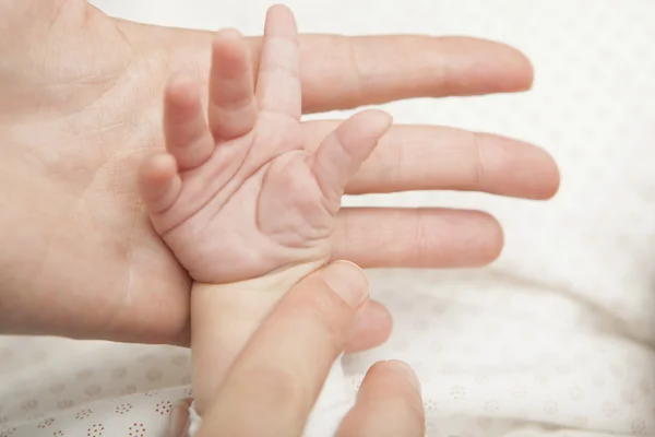 Madre sosteniendo la mano del bebé — Foto de Stock