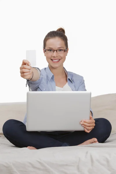 Mulher segurando um cartão de crédito ao usar laptop — Fotografia de Stock