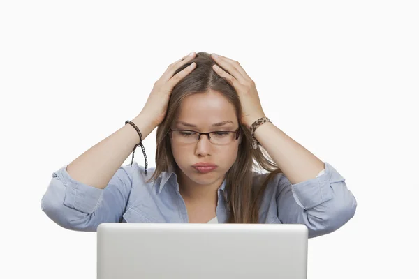 Frau schaut besorgt bei der Arbeit am Laptop Stockfoto