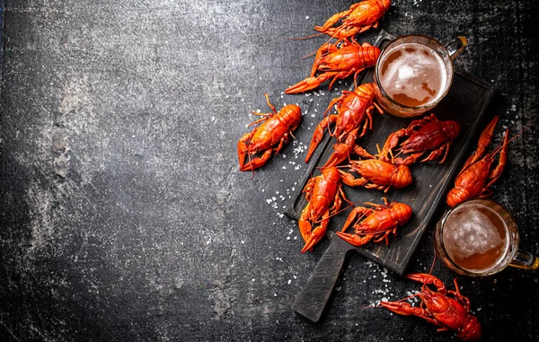 Boiled crayfish with beer on a cutting board.