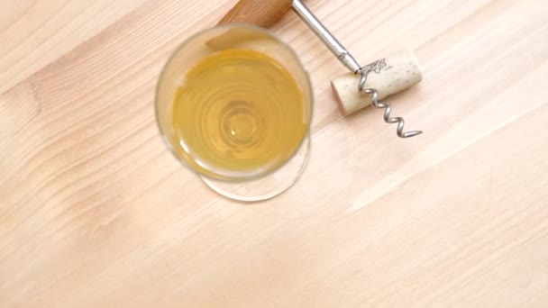 Corkscrew, cork and glass of white wine — Stock Video