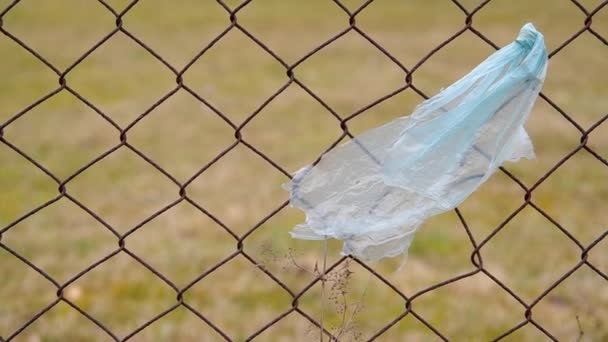 Пластиковий пакет прив'язаний до паркану — стокове відео