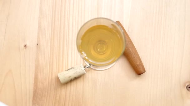 Kurkentrekker, cork en glas witte wijn — Stockvideo