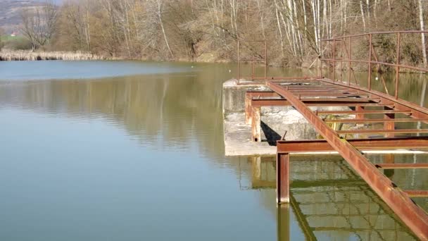 Muelle en la orilla de un estanque — Vídeo de stock