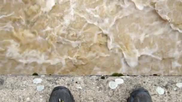 Mann überlegt, ob er in den stürmischen Fluss springen soll — Stockvideo