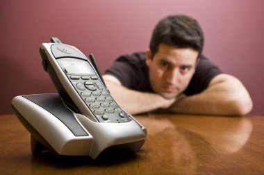Man looks at the phone. Waiting clipart