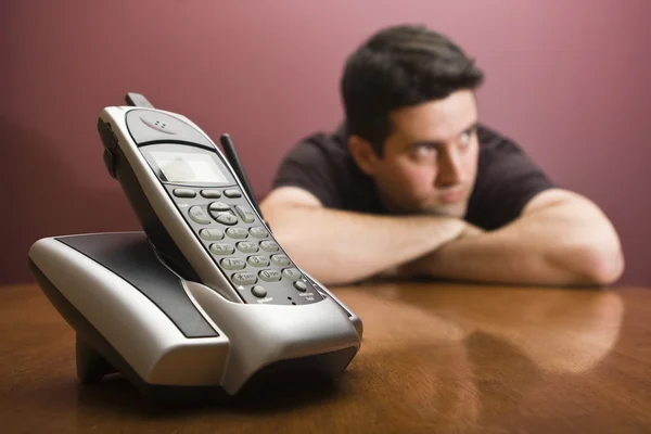 Homem está entediado esperando o telefone tocar . — Fotografia de Stock