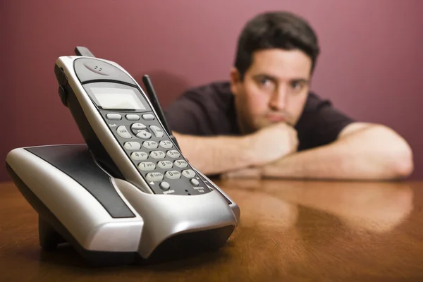 Homem olha para o telefone à espera de uma chamada — Fotografia de Stock