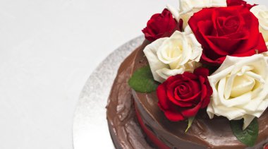 Çikolatalı pasta üzerinde kırmızı ve beyaz güller