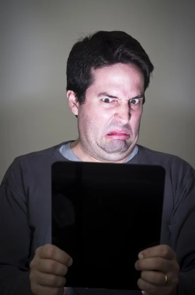 El hombre está disgustado por lo que ve en un dispositivo de tableta — Foto de Stock