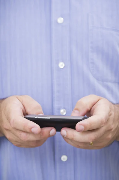 Homem de negócios casual digita uma mensagem em seu smartphone touchscreen — Fotografia de Stock