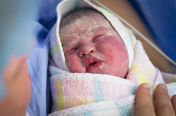 Лицо новорожденного ребенка, которого держит его мать — стоковое фото