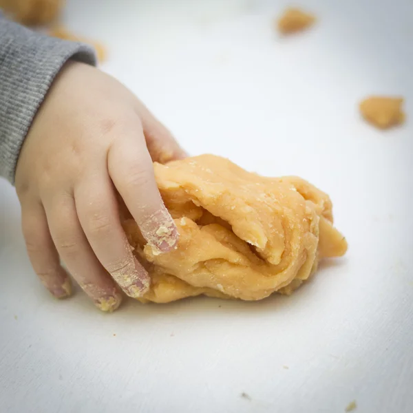 Un jeune enfant ramasse de la pâte à modeler Images De Stock Libres De Droits