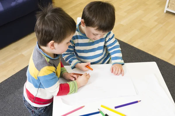 Twin boys drawing at a table together — Stock Photo, Image