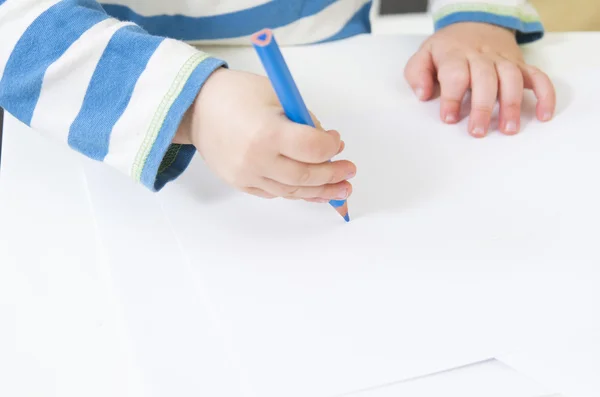 Småbarn ritar med en blå penna — Stockfoto