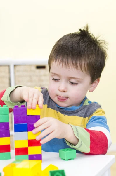 Jonge jongen speelt met het aansluiten van bakstenen — Stockfoto