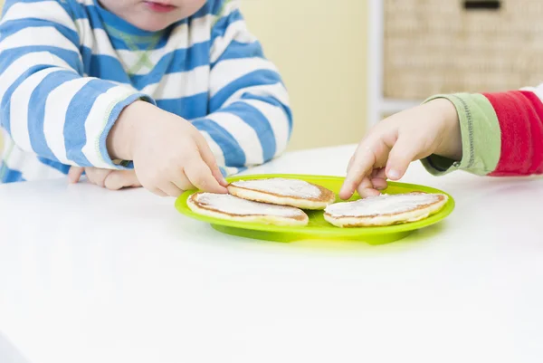 Young boys reaching for pikelets — Stock Photo, Image