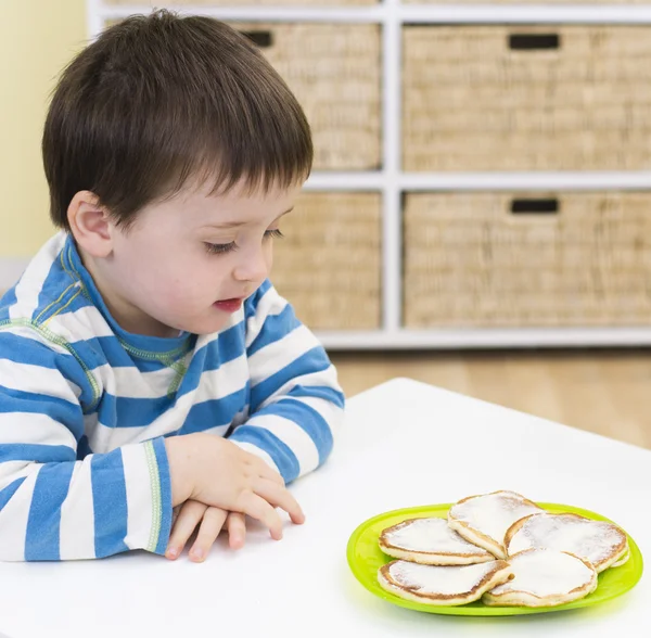 Jonge jongen te wachten om te eten pikelets — Stockfoto