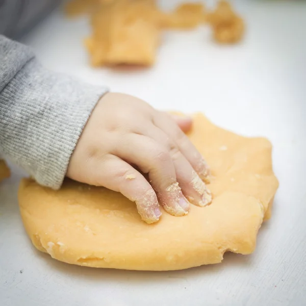 Child plays with orange playdough — Stock Photo, Image