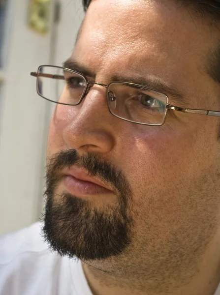 Man with beard and glasses looks left intently — Stock Photo, Image