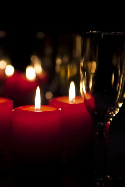 Sektflöte und rote Kerzen — Stockfoto