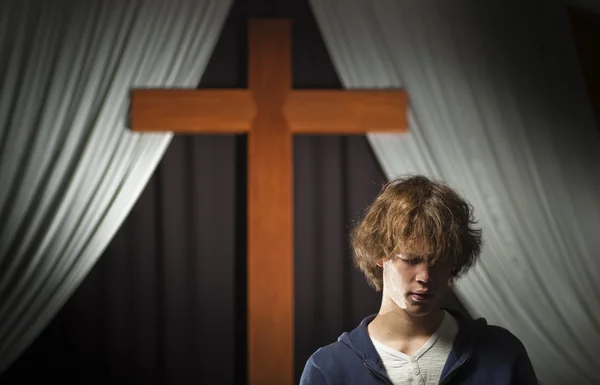 Teenager betet vor einem Kreuz — Stockfoto