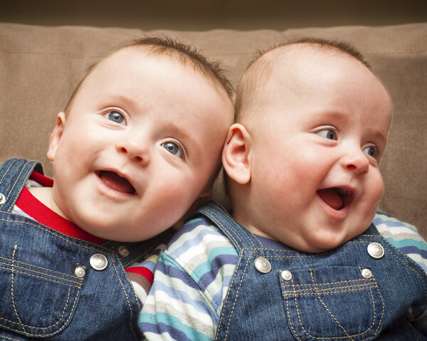 Мальчики-близнецы в комбинезоне улыбаются
