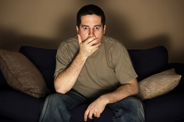 Man shocked by what he sees on the television — Stock Photo, Image