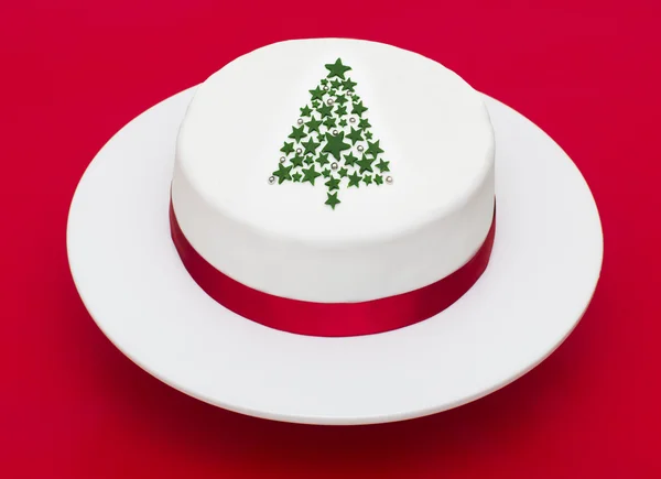 赤い背景の上のクリスマス ツリーのケーキ ストックフォト