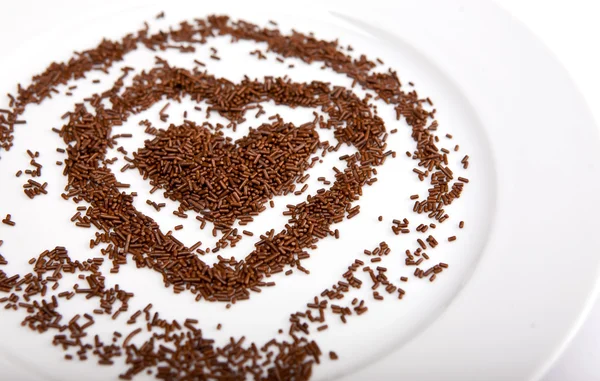 Heart of chocolate chips on a white plate porcelain — Stock Photo, Image