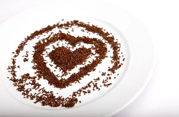 Η καρδιά των τσιπ σοκολάτας για ένα λευκό πιάτο πορσελάνης — Φωτογραφία Αρχείου
