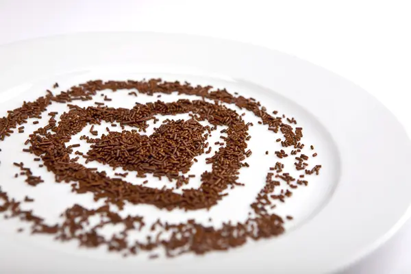 Heart of chocolate chips on a white plate porcelain — Stock Photo, Image